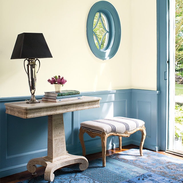 Une entrée accueillante avec des murs blanc cassé et un joli bleu sur le lambris d’appui et les boiseries de la fenêtre et de la porte. Une entrée accueillante avec des murs blanc cassé et un joli bleu sur le lambris d’appui et les boiseries de la fenêtre et de la porte.