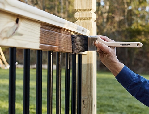 Application de teinture au pinceau sur une balustrade en bois. Application de teinture au pinceau sur une balustrade en bois.