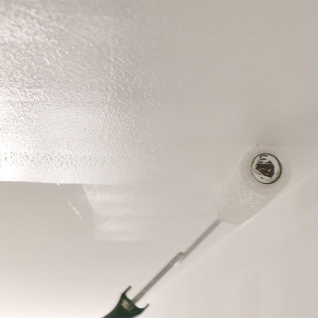 Gros plan d’un plafond en train d’être peint en blanc. Gros plan d’un plafond en train d’être peint en blanc.